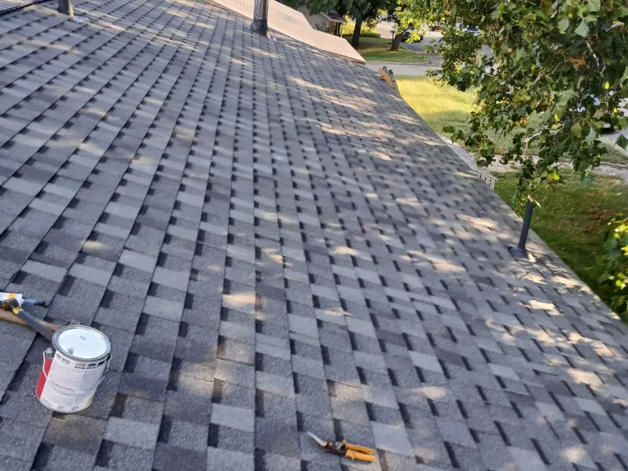 Roof in progress with sealant and hand tools beside new pipe boots