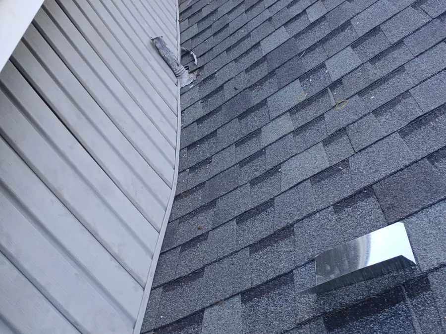 Close view of shingles running into a valley against lap siding